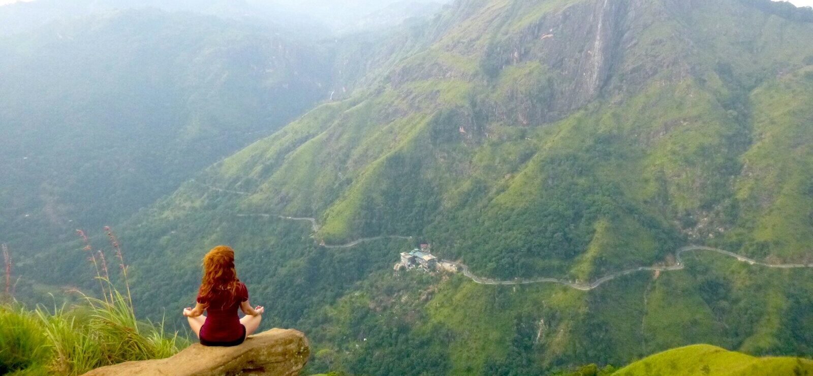 woman sitting on brown rock